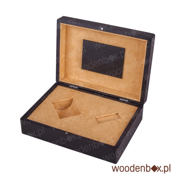 Kasetka drewniana na perfumy wykonana na zamówienie. W środku są dwa otwory. Całość wyścielona ręcznie tkaniną alcantara. Opakowanie drewniane ma też tabliczkę drewnianą w wieczku. Na niej robi się logo firmy laserem albo hot stamp